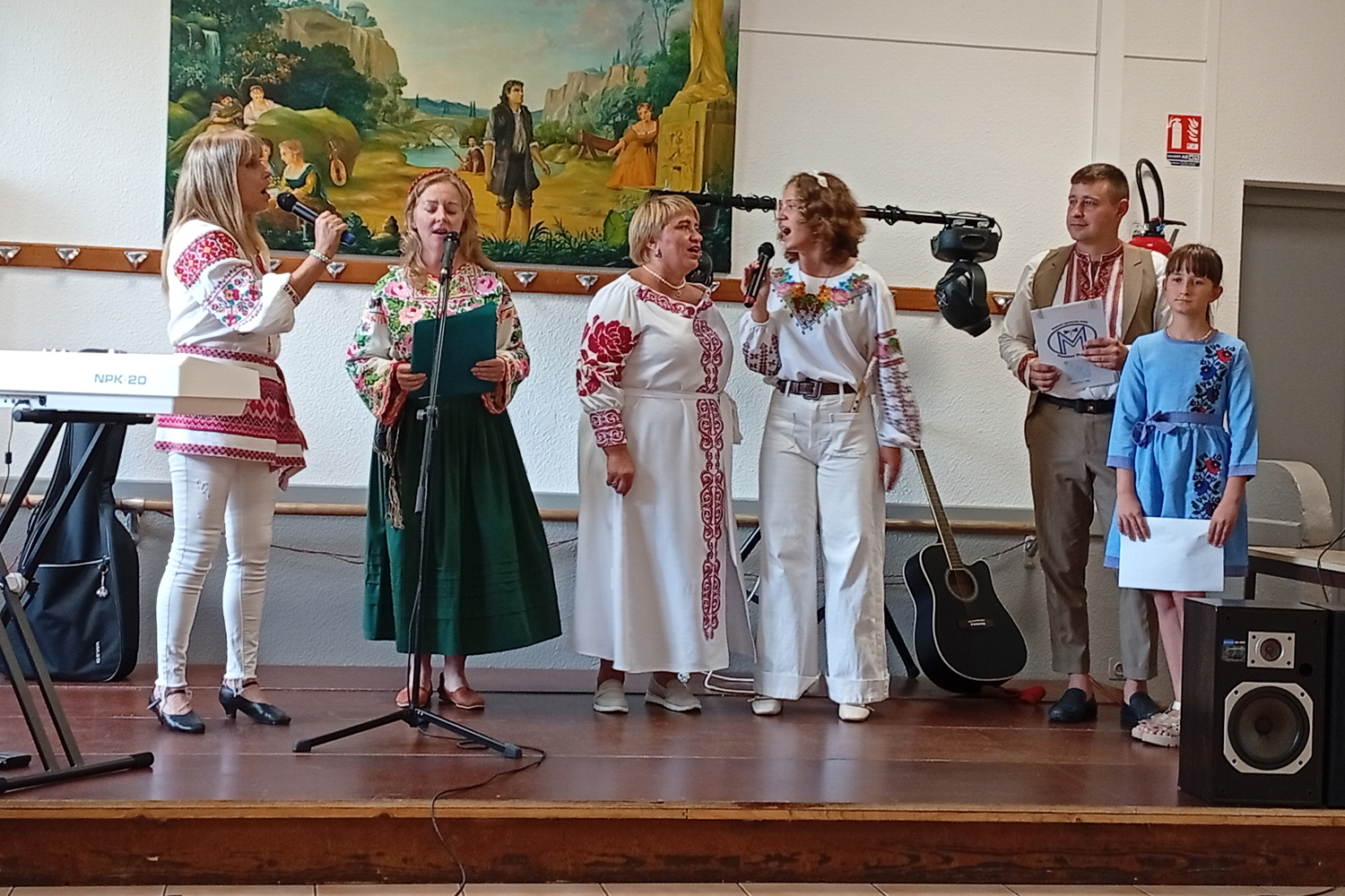 Scène de la fête : chanteuses ukrainiennes et jeune présentatrice ; traduction en français